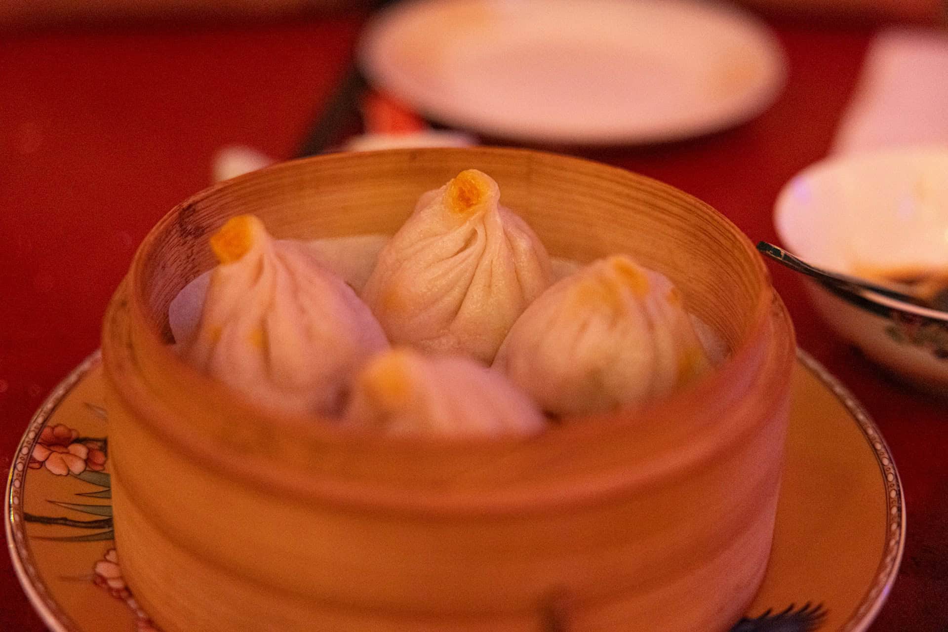 Soup-filled buns steaming in a bamboo basket