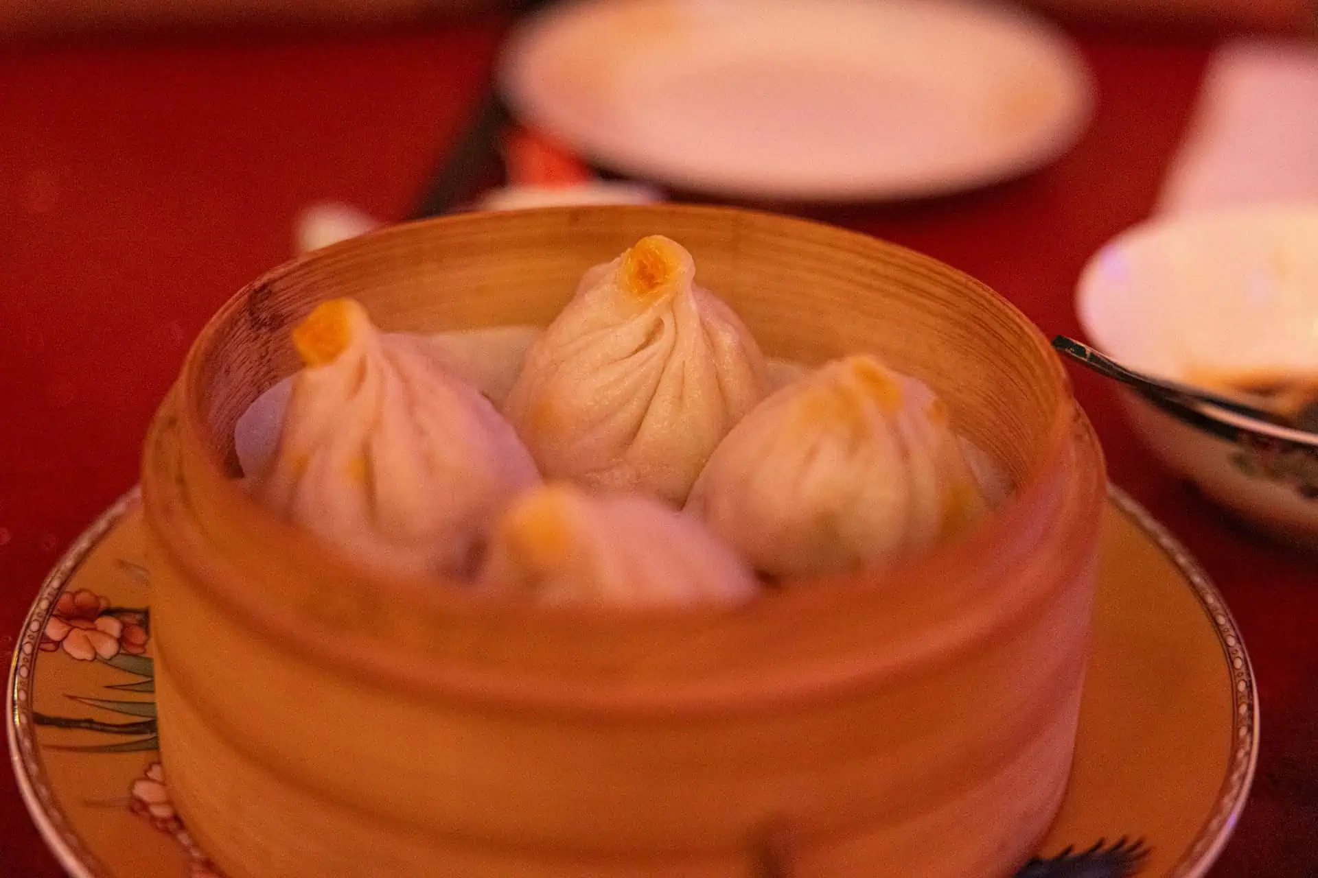 Soup-filled buns steaming in a bamboo basket
