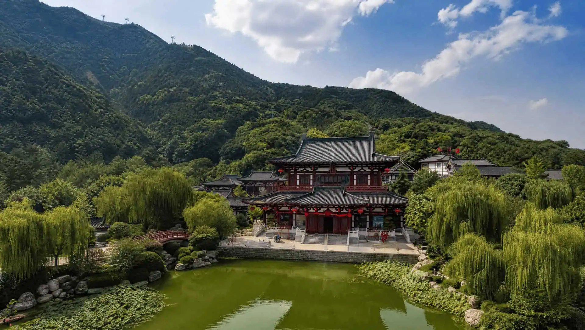Huaqing Palace's halls and lake spread below Mount Li at dusk