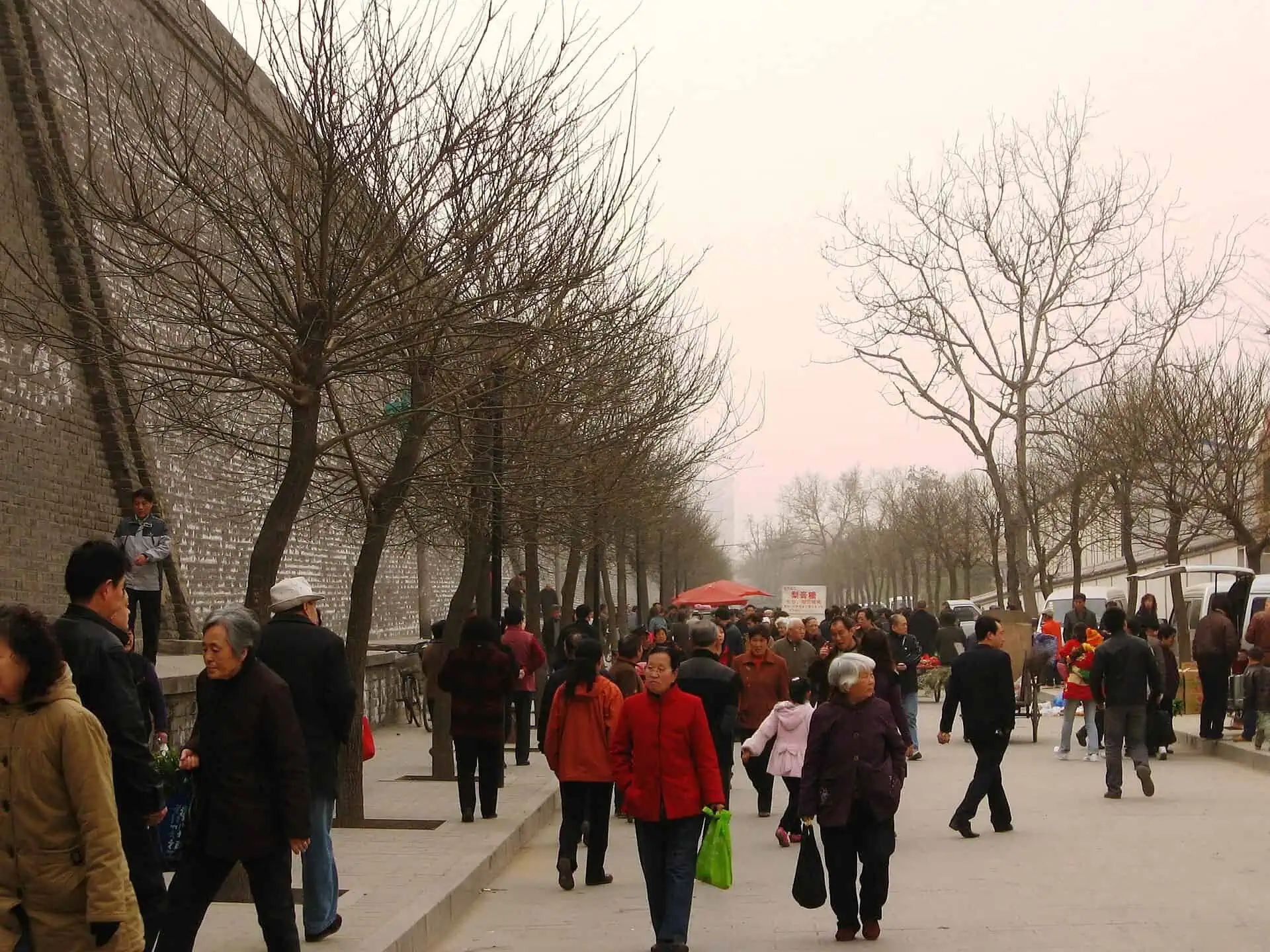 Early-morning market crowds shopping along the foot of Xi'an's city wall