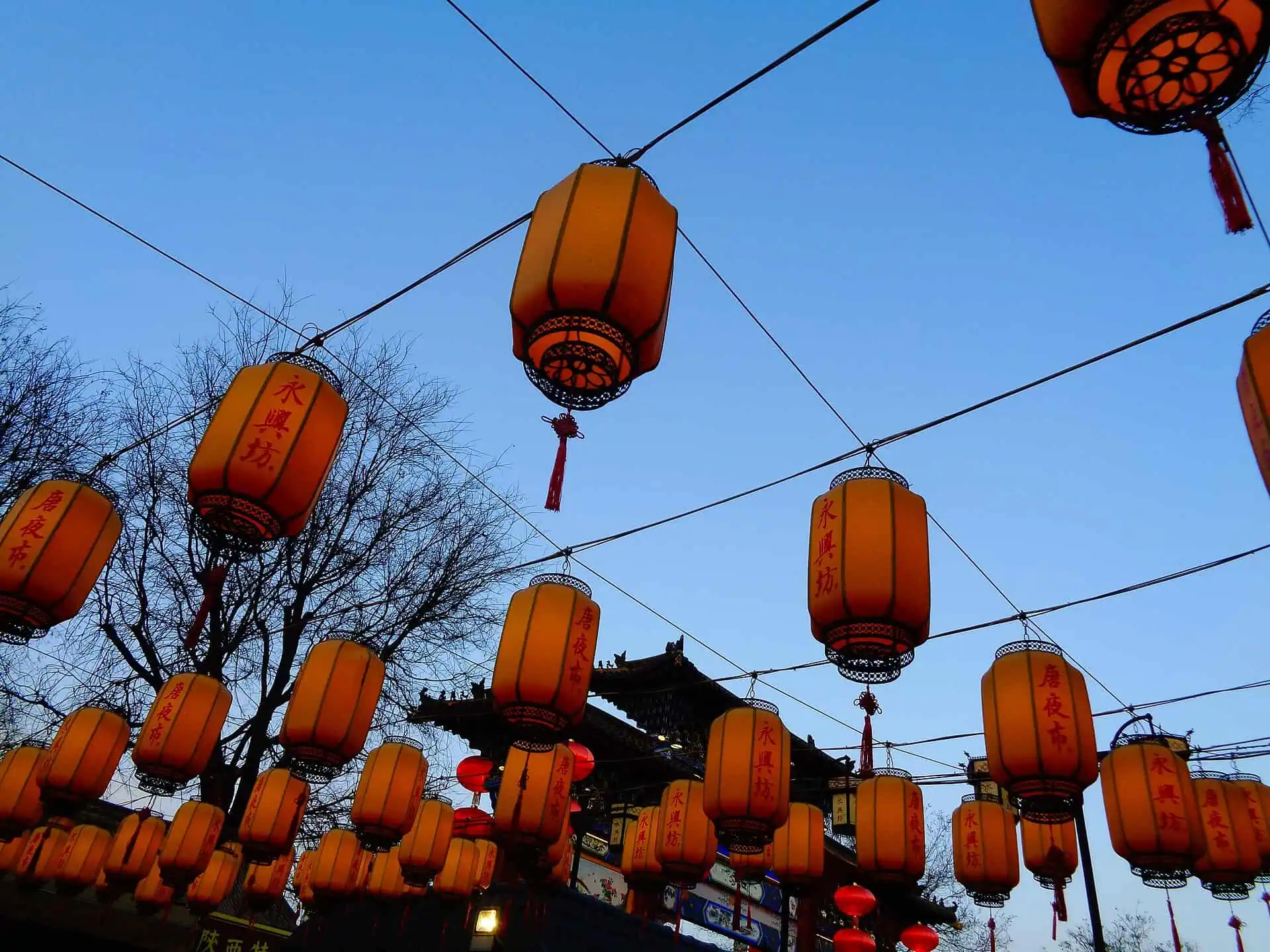 Red lanterns lettered 'Yongxingfang' strung over the heritage food street at dusk